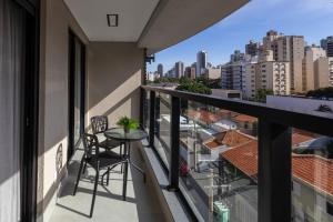 a balcony with a table and a view of the city at Elegante Apartamento no Cambuí in Campinas