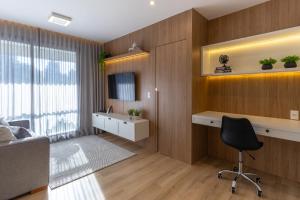 a office with a desk and a chair in a room at Elegante Apartamento no Cambuí in Campinas