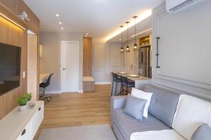 a living room with a couch and a kitchen at Elegante Apartamento no Cambuí in Campinas