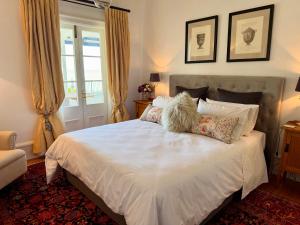 a bedroom with a large white bed with pillows at Villa Victoria - Nelson in Nelson