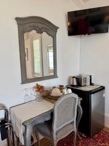 a kitchen with a table and a mirror on the wall at Villa Victoria - Nelson in Nelson
