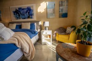 a bedroom with a bed and a chair and a table at Ajuga Luxury Boutique B&B in Qala +68 photos