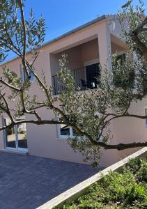 a house with a tree in front of it at Apartments Verde in Lumbarda