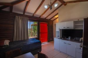 a kitchen with a red door in a room at CABAÑAS EL CERRO in Ciudad Lujan de Cuyo