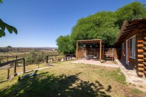 a log cabin with a patio and a fence at CABAÑAS EL CERRO in Ciudad Lujan de Cuyo