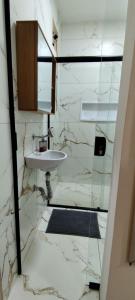 a white bathroom with a sink and a mirror at Studio Figueira, Flor in Santarém +10 photos