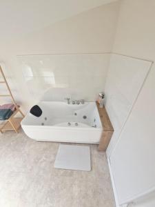 a white bathroom with a bath tub in a room at Studio cosy in Burlats