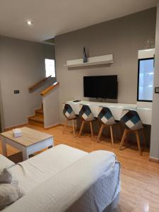a living room with a couch and a desk with a television at El Rincón de Playasol in Puerto de Mazarrón