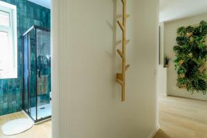 a room with a glass door with a plant on the wall at La Canopée - Bohemian - chic apartment in Lens
