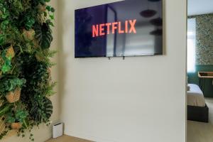 a room with a netflix sign on the wall at La Canopée - Bohemian - chic apartment in Lens