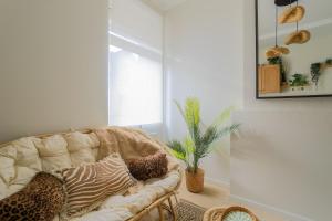 a living room with a couch with pillows on it at La Canopée - Bohemian - chic apartment in Lens