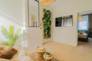 a living room with a couch and a plant on the wall at La Canopée - Bohemian - chic apartment in Lens +23 photos