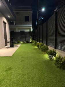 a yard with green grass in a building at night at Kalvokoresi 16 I Premium Apartments in Chios +74 photos
