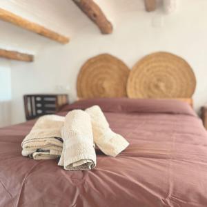 a bed with two towels on top of it at Escapada rural en Nulles, cerca de Tarragona in Nulles