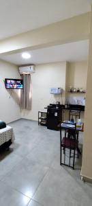 a room with a table and chairs and a kitchen at Studio Figueira, Flor in Santarém