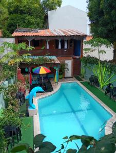 a pool in front of a house with a resort at Pousada e Restaurante Morena Raiz in Olinda