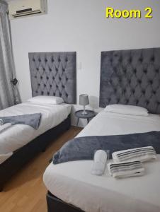 a bedroom with two beds and a large headboard at Kliprivier Accommodation in Johannesburg