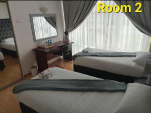 a hotel room with two beds and a mirror at Kliprivier Accommodation in Johannesburg