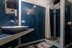 a blue tiled bathroom with a sink and a shower at Maestosa Maison della Cattedrale, 3 piani storici tutti per voi! in Sutri +19 photos