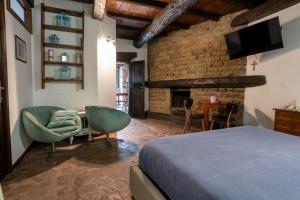 a bedroom with a bed and a table and a fireplace at Maestosa Maison della Cattedrale, 3 piani storici tutti per voi! in Sutri