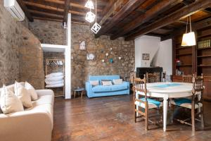a living room with a table and a blue couch at Maestosa Maison della Cattedrale, 3 piani storici tutti per voi! in Sutri