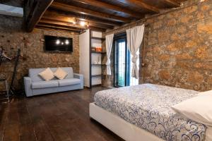 a bedroom with a bed and a couch in a room at Maestosa Maison della Cattedrale, 3 piani storici tutti per voi! in Sutri