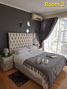 a bedroom with a large bed with a large window at Kliprivier Accommodation in Johannesburg