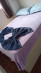 a robe is laying on a bed at Quarto IV V VI in Curitiba