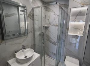 a bathroom with a sink and a glass shower at Merlin Prestige Apartments in Budva +63 photos