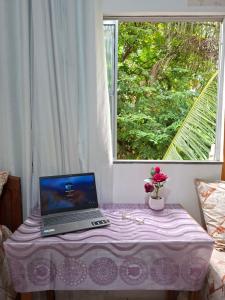 a laptop computer sitting on a table in front of a window at cantinho da Raq,um quarto SUÍTE com ar condicionado duas camas de casal perto doAeroporto, UEPA, Rodoviaria, magueirao, UFPA,parque ambiental, in Belém