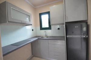 a kitchen with white cabinets and a stainless steel refrigerator at Adriolos Apartments in Liapades +8 photos