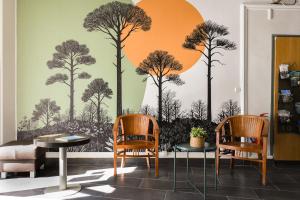 a living room with a wall mural of trees at Hotel Le Coureau in Saint-Trojan-les-Bains
