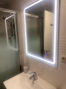 a bathroom with a sink with a mirror and a shower at Habitación Doble con Aire cerca de la Playa in Benidorm