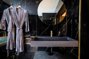 a bathroom with a sink and a mirror at Golden Suite - Elegance - Private Spa Jacuzzi in Lens