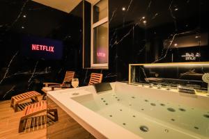 a large bath tub in a room with chairs at Golden Suite - Elegance - Private Spa Jacuzzi in Lens +29 photos
