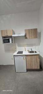 a kitchen with a sink and a stove top oven at Homeday joffre 3 type f2 in Haguenau