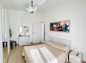 a white bedroom with a bed and a bathroom at Casa tua a Pergusa in Pergusa