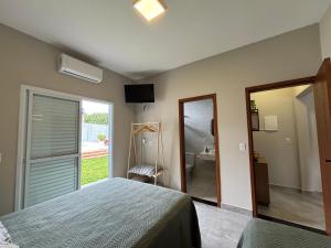 a bedroom with a bed and a mirror and a bathroom at Suítes Brotas in Brotas