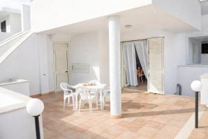 a white dining room with a white table and chairs at ONDA BLU-Appartamenti in Torre dell'Orso