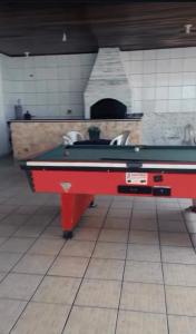 a pool table in a kitchen with a pizza oven at Residêncial Allah in Peruíbe
