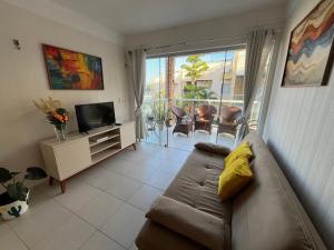 a living room with a couch and a television at Apartamento Duplex vista mar Buzios in Nísia Floresta