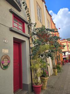 a red door on the side of a building with plants at Apto RUA DO LAZER in Santa Teresa