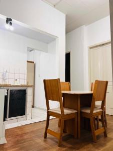 a kitchen with a wooden table and two chairs at Apto RUA DO LAZER in Santa Teresa