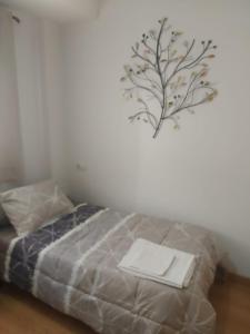 a bedroom with a bed with a branch on the wall at El Refugio de la montaña in Arroyo Frio