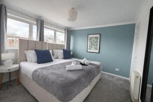 a bedroom with a large bed with blue walls at Daisy House- Sleeps 7- Driveway Parking, Contractors, Fast Wifi and Smart TV in Oxford