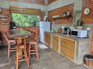 a kitchen with a counter with stools and a refrigerator at Alojamiento Mariana y Ocho Oñondive in Villa Concepción