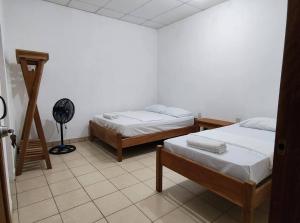 a room with two beds and a fan in it at Hostal Jireh in Altagracia