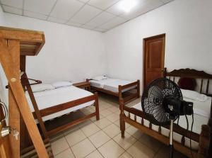 a room with two bunk beds and a fan at Hostal Jireh in Altagracia