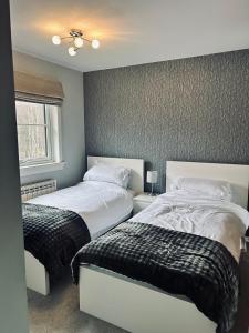 a bedroom with two beds and a window at 6 Carn Dearg House in Aviemore
