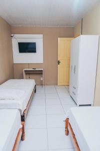 a hospital room with two beds and a refrigerator at Casa Celeste in Boa Vista